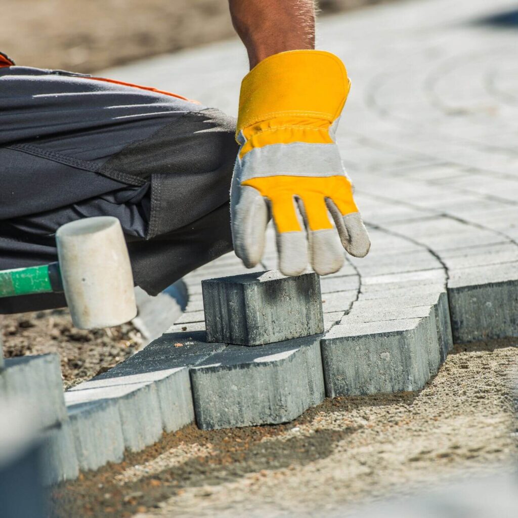 Builder installing Brick Paving | Building Material Reviews